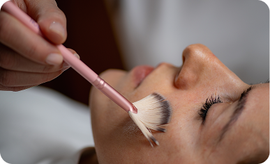 Aesthetician applying a VI Peel chemical peel to a patient's face.